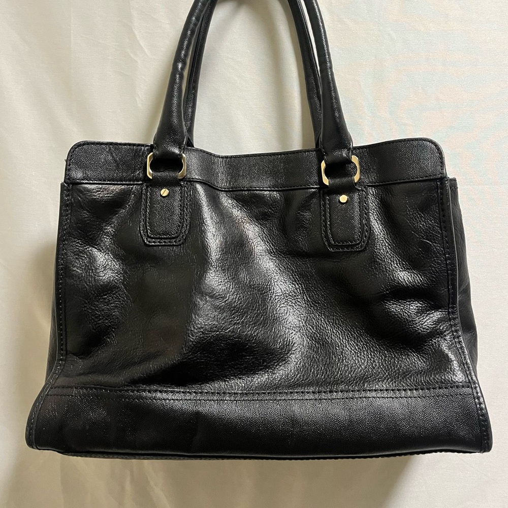 Black Cole Haan leather handbag with zipper pocket and a magnetic snap closure.